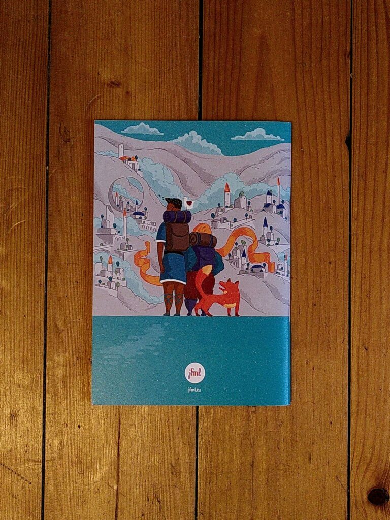 Photo of a the backside of a small booklet on a wooden background. On it are two drawn figures turned away from the viewer with backpacks and a fox looking at a city on a mountainside.