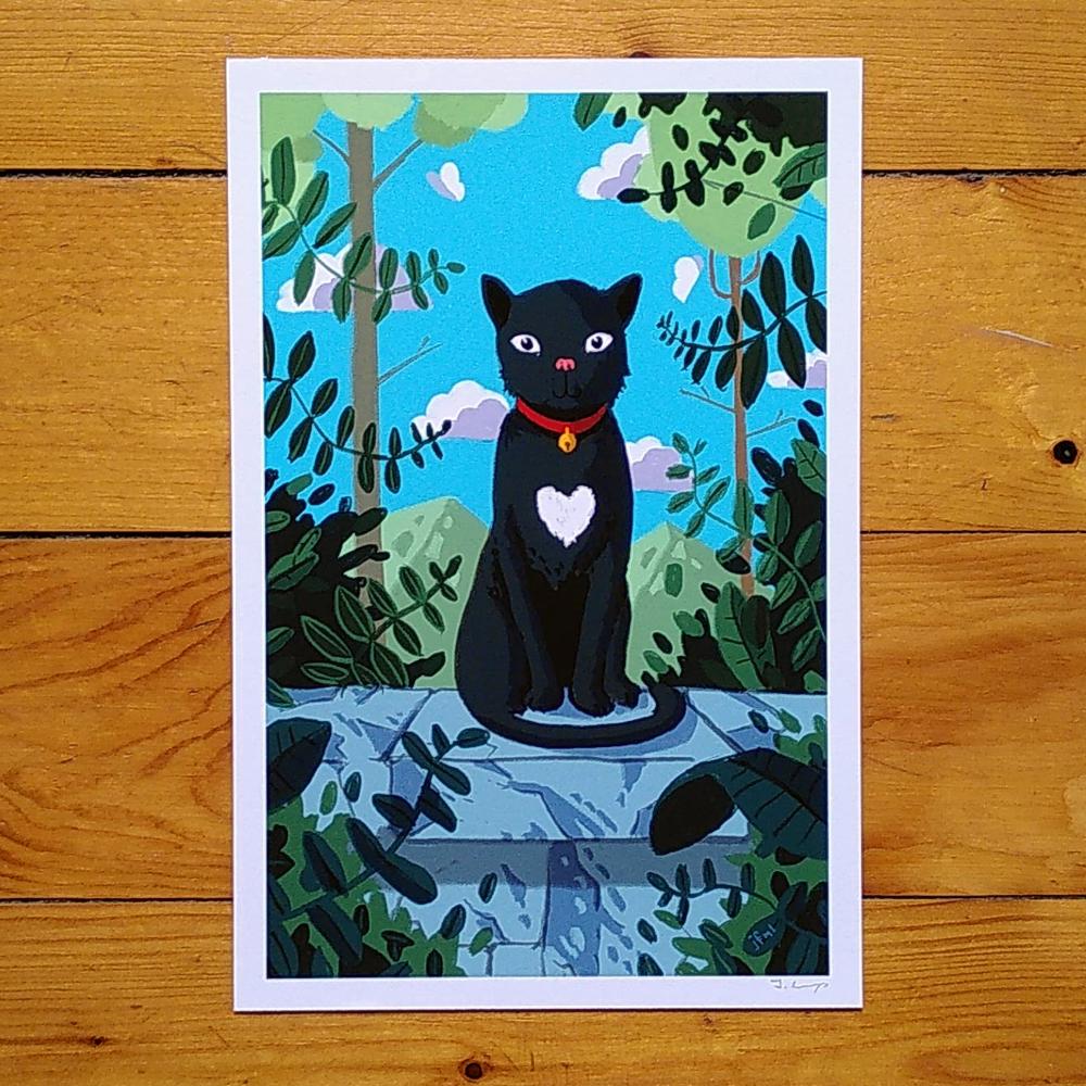 Photo of a print with a black cat that has a cute heart-shaped spot on their breast.